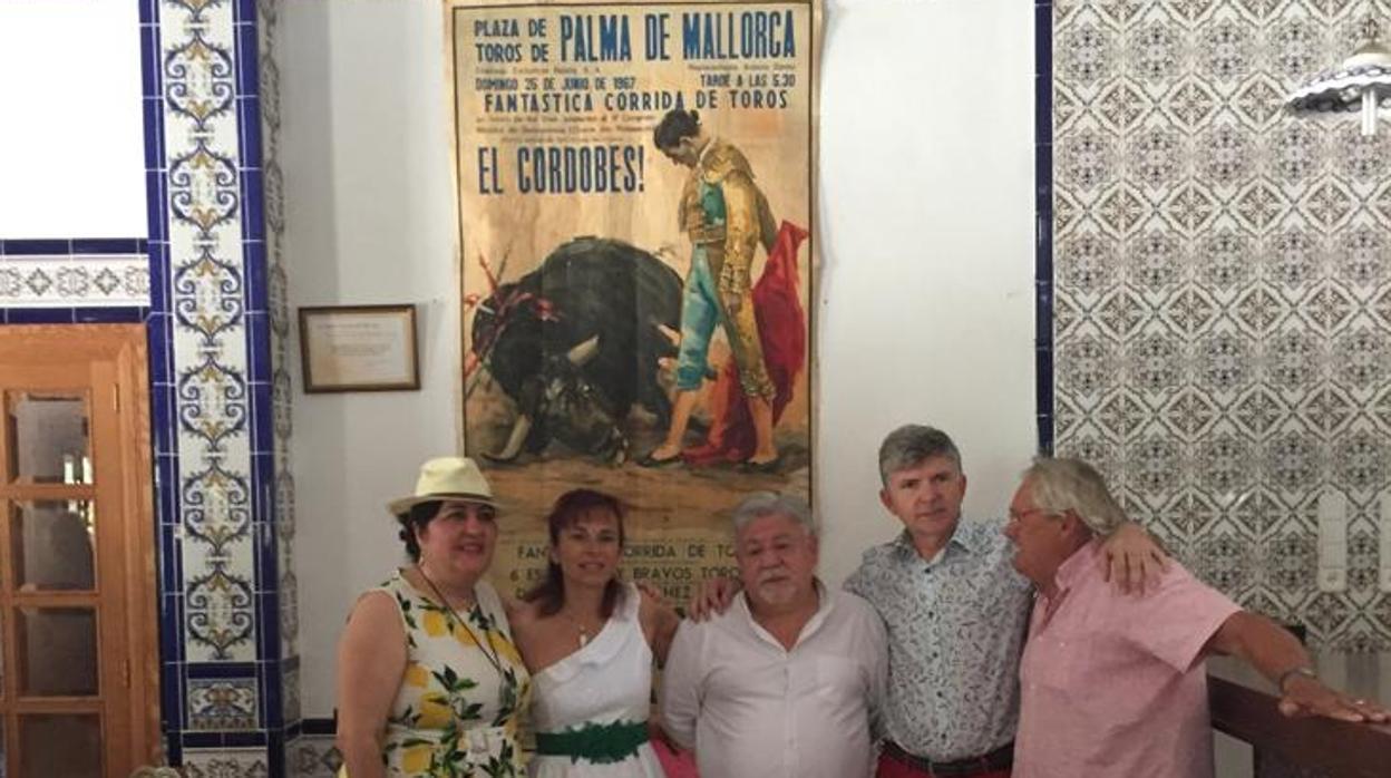 Miembros de la peña, con el presidente en el centro, posan junto a un cartel de toros en Palma