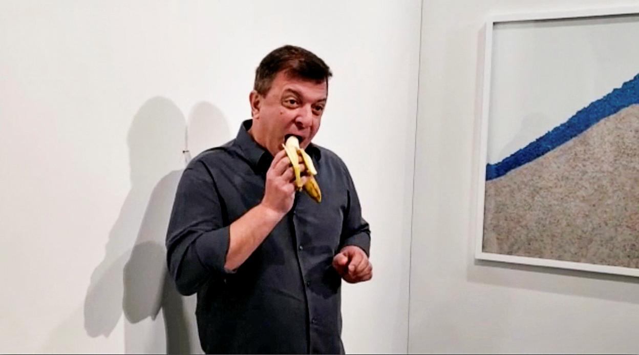 David Datuna, en el momento de comerse el plátano de Maurizio Cattelan