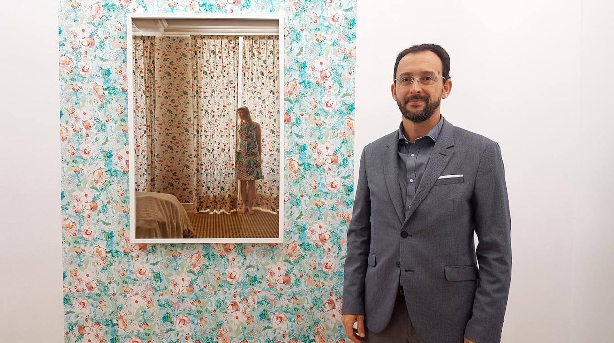 El galerista Juan Curto, junto con una obra de la artista Elina Brotherus