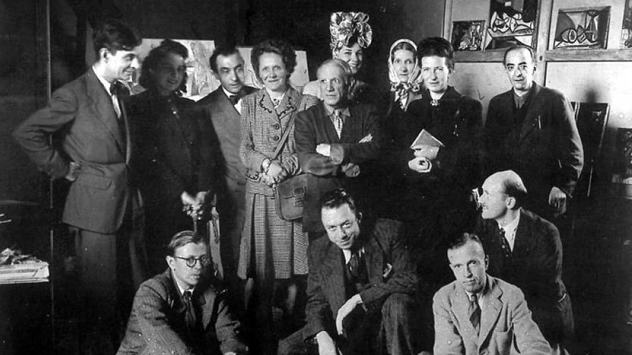Camus (agachado, en el centro, junto a Sartre) en el estudio de Picasso