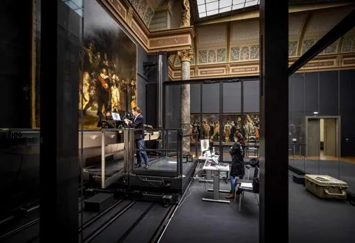 Imagen tomada ayer, donde dos trabajadores del Rijksmuseum analizan el cuadro manteniendo la distancia de seguridad exigida