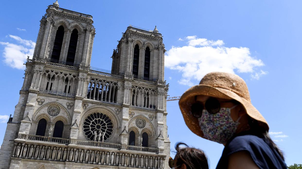 Una mujer, con una mascarilla, en la reabierta explanada de la catedral de Notre Dame, en París