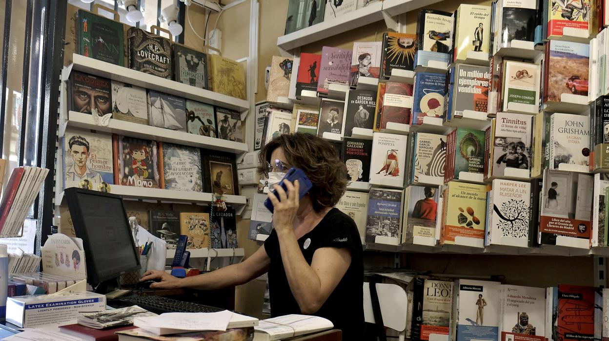 Una librera de El Gusanito Lector, en Sevilla, ataviada con una mascarilla