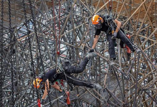 Dos trabajadores, entre los andamios de Notre Dame