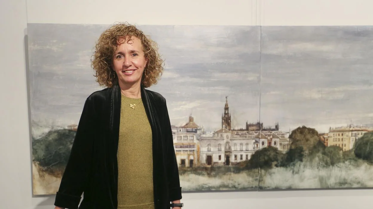 Lola Montero ante el díptico con la vista de Sevilla