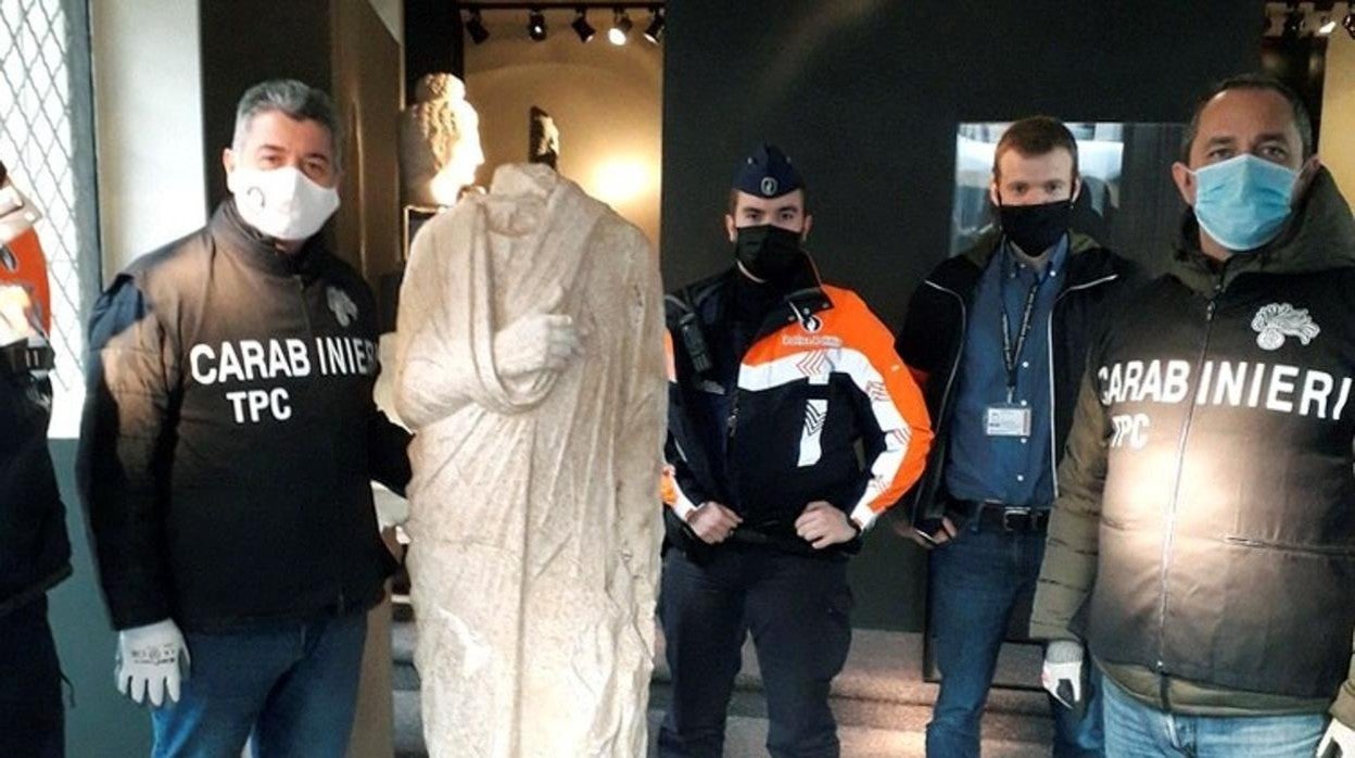 Los policías italianos, junto a la escultura romana que ha sido recuperada