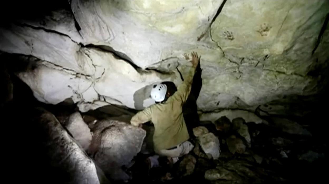 El arqueólogo Sergio Grosjean muestra las manos pintadas en la cueva de México