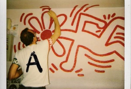 Fotografía tomada por César de Melero en la que se ve a Haring pintando el mural