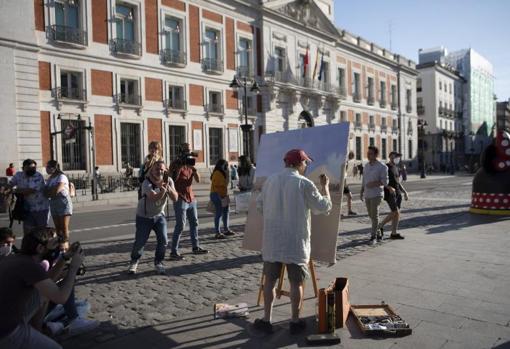 Antonio López, en plena faena, con la Real Casa de Correos al fondo