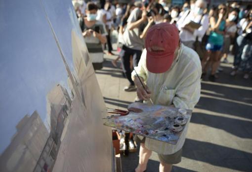 El artista manchego, paleta en mano pintando el lienzo que se halla sobre el caballete