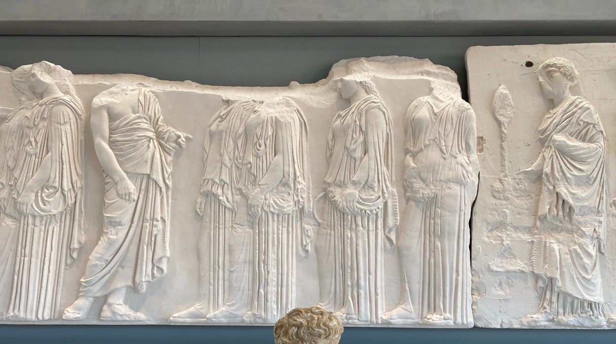 Uno de los fragmentos de las esculturas del Partenón junto al friso