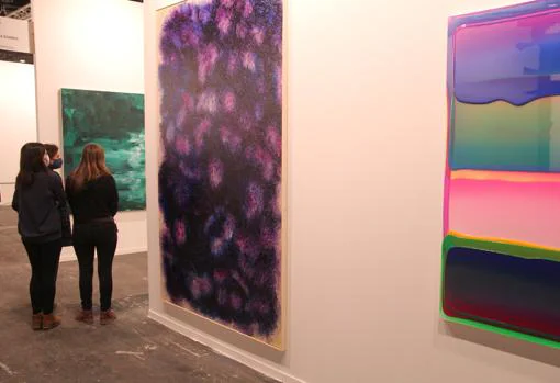 Tres mujeres admiran las obras en el espacio de Filomena Soares