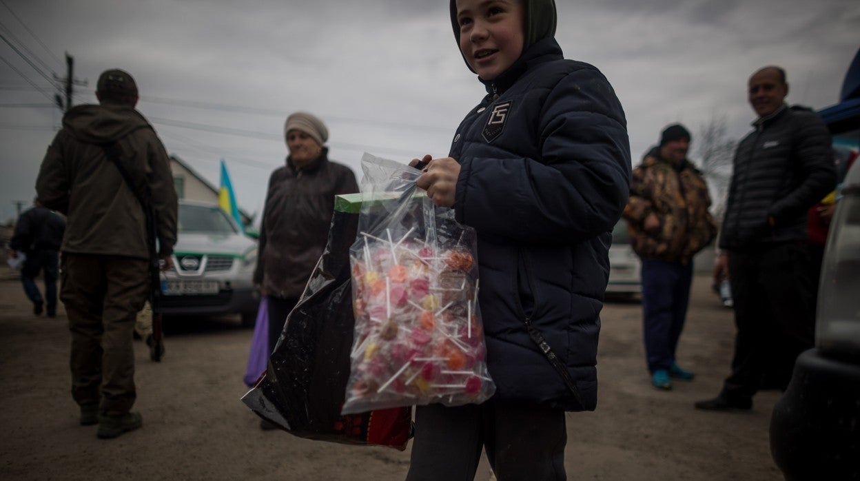 Un niño sonríe tras recibir una bolsa de piruletas en el pequeño pueblo de Rozhivka, a unos 40 kilómetros al noreste de Kiev