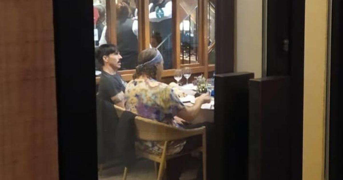 En la imagen, Anthony Kiedis, cantante de Red Hot Chili Peppers, junto a otra persona comiendo en Casa Robles del Centro