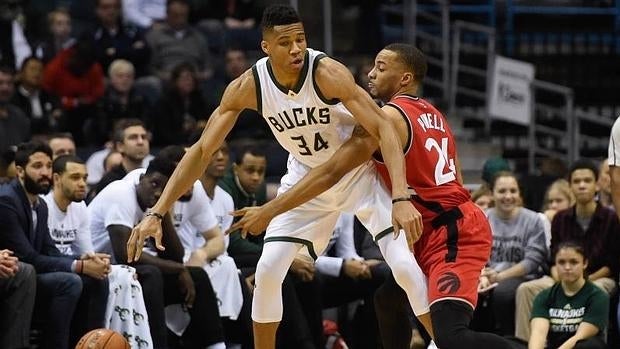 Giannis Antetokounmpo bota el balón ante un jugador de los Toronto Raptors