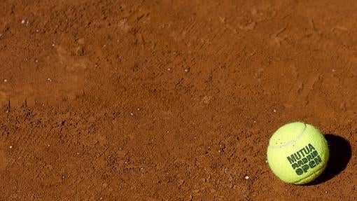 Una pelota sobre la tierra batida en una pista de la Caja Mágica