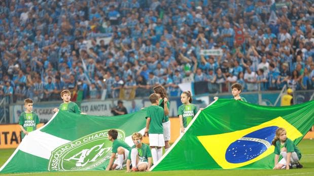 Banderas del Chapecoense y de Brasil, antes de un partido de fútbol