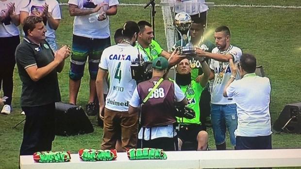 Neto, izquierda, Jackson Follman, en silla de ruedas, y Alan Ruschel, en el Arena Condá