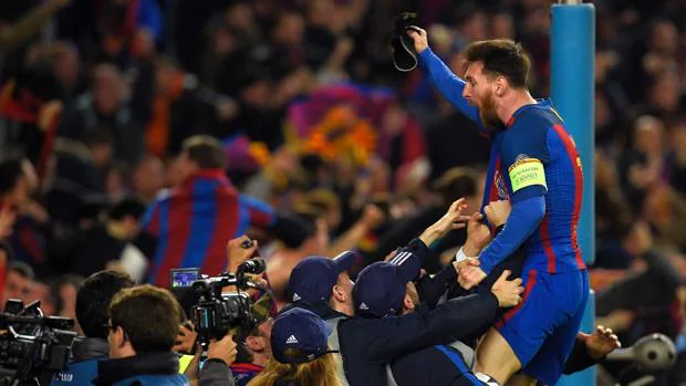 Leo Messi celebra la clasificación del Barcelona subido a una valla del Camp Nou