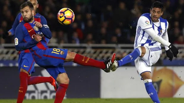 Jordi Alba intenta cortar un disparo de Carlos Vela en el partido que el Barcelona jugó ante la Real Sociedad