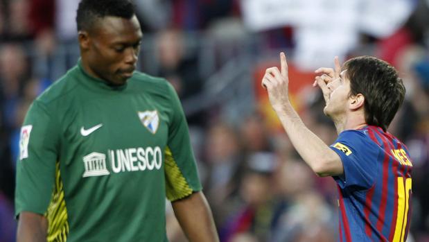 Leo Messi celebra uno de los goles que le ha marcado al Málaga ante un cabizbajo Carlos Kameni