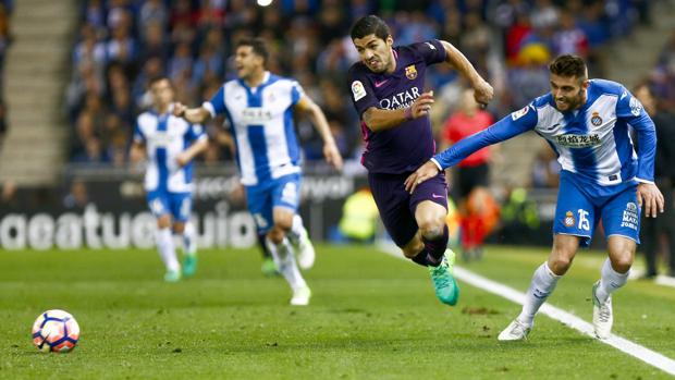 Luis Suárez pelea un balón con David López durante el partido entre el Español y el Barcelona