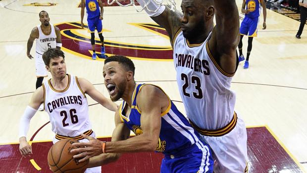 LeBron James trata de evitar una canasta de Stephen Curry