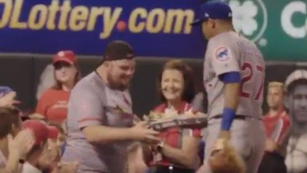 Un jugador de béisbol trae nachos a un aficionado