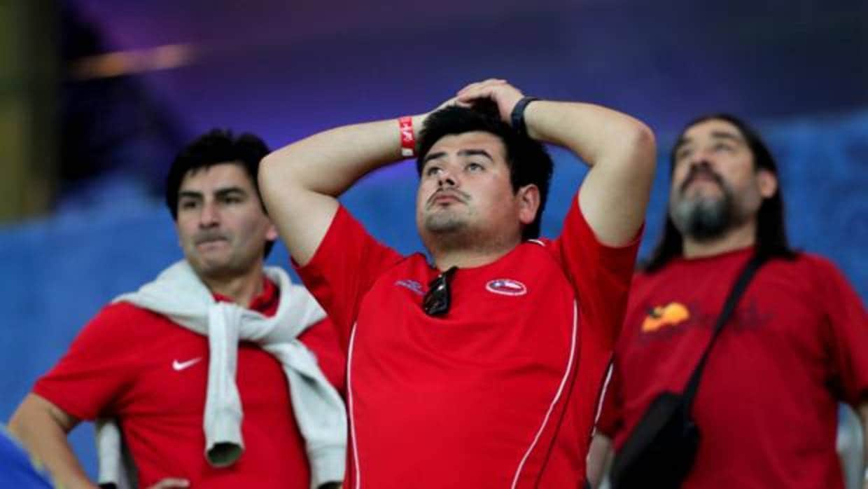 Aficionados de la selección chilena se lamentan tras la derrota de su equipo ante Brasil
