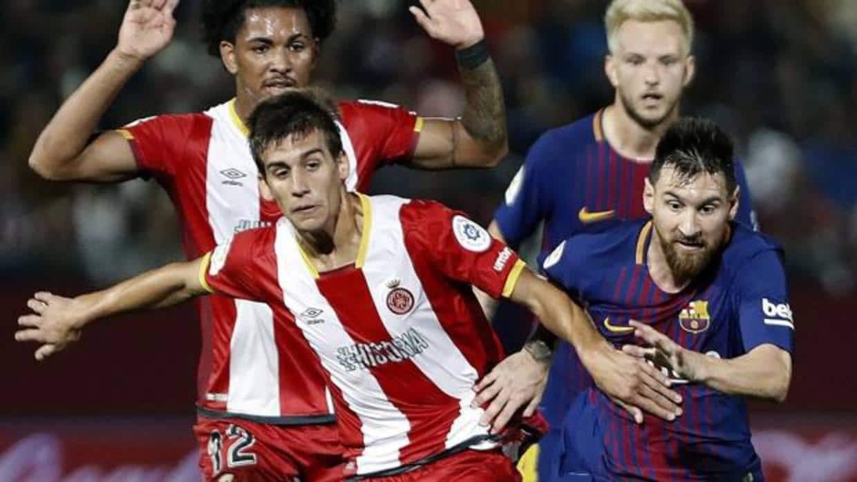 Pere Pons trata de frenar a Messi durante el partido disputado en Montilivi