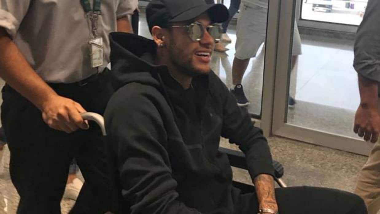 Neymar, en una silla de ruedas a su llegada al aeropuerto de Río de Janeiro (Brasil)