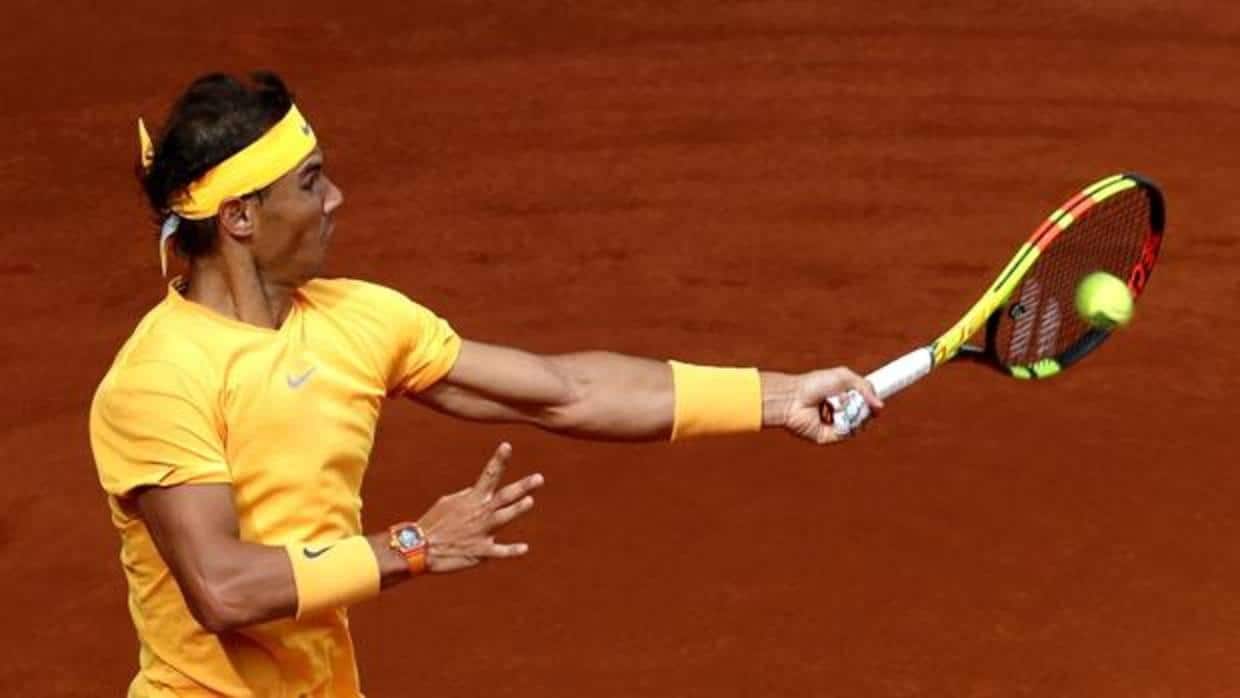 El tenista español Rafa Nadal devuelve la bola al francés Gael Monfils