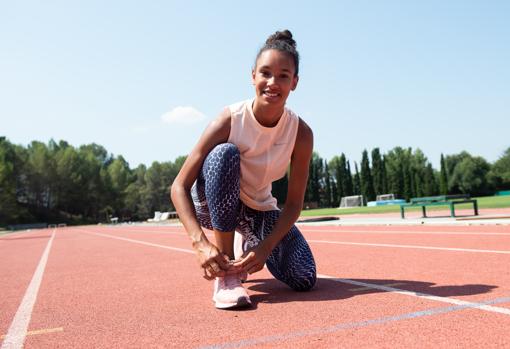 La atleta española se ata las deportivas durante la sesión de fotos