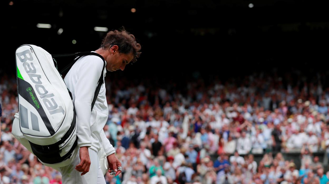 Nadal sale de la pista central de Wimbledon tras caer en la semifinal cotnra Djokovic