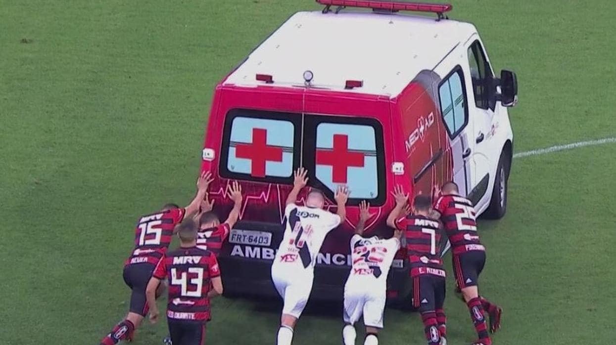 Los jugadores del Vasco de Gama y del Flamengo, empujando la ambulancia
