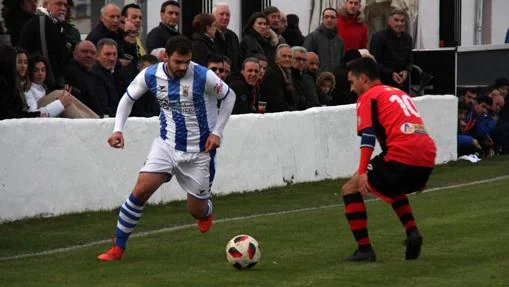 Un jugador del Náxara intenta superar a un rival del FC La Calzada