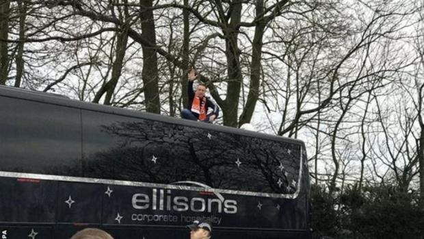 Un hincha del Blackpool se sube encima del bus del Arsenal