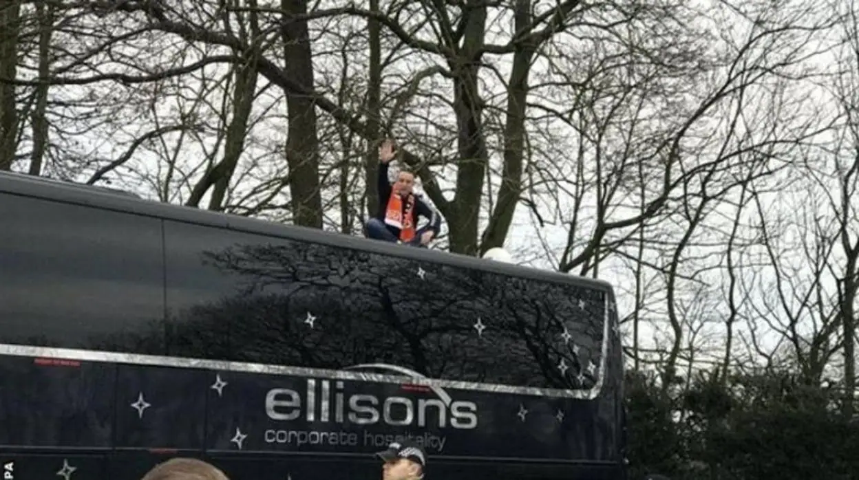 Un aficionado se siente encima del autobús del Arsenal