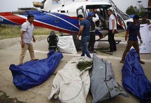 El personal del Ejército de Nepal trae cuatro cadáveres en un helicóptero para la autopsia