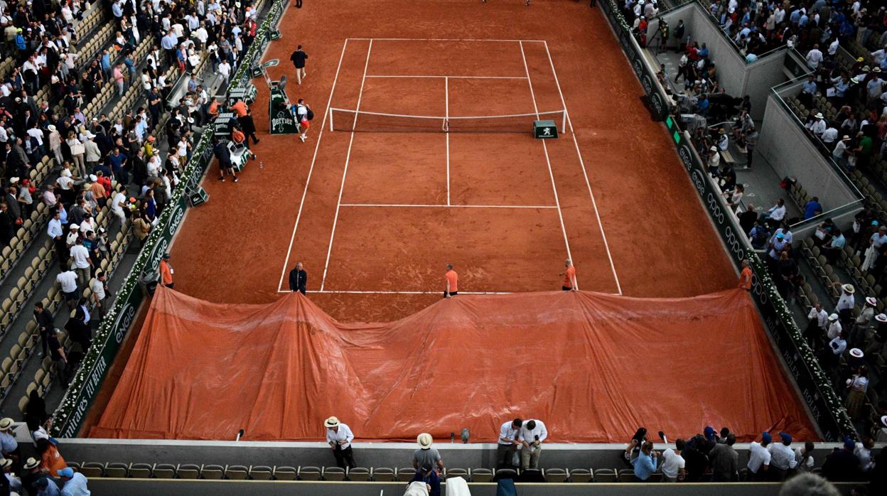 Los pisteros cubren la tierra batida de la Suzanne Lenglen