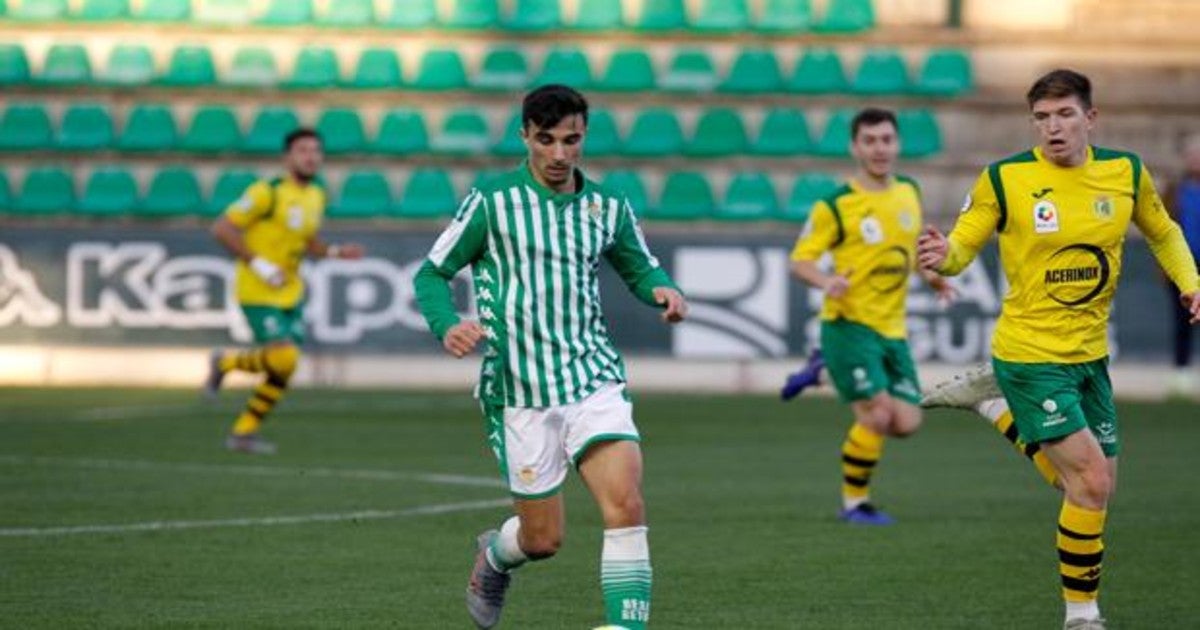 Robert, del Betis Deportivo, conduce un balón ante la atenta mirada de Urri, de Los Barrios