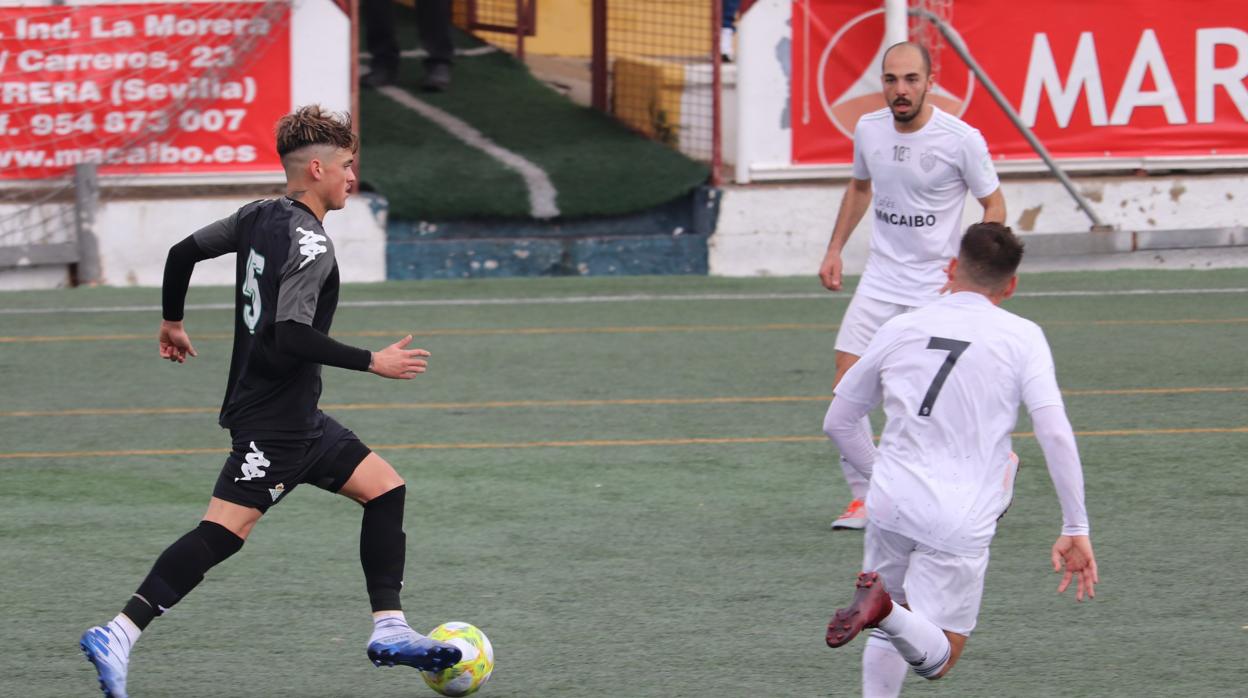 Geovanni, del Betis Deportivo, conduce ante la mirada de Plusco, del Utrera