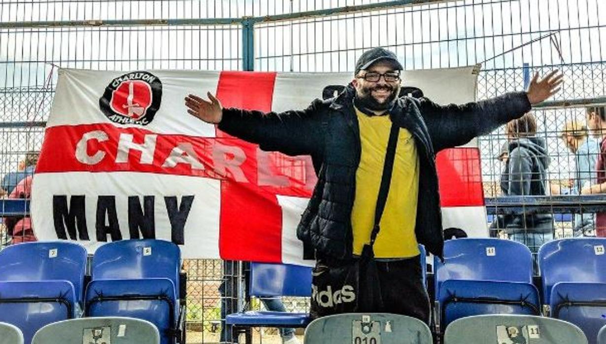 Seb Lewis posando con una bandera del Charlton, el equipo del que era seguidor