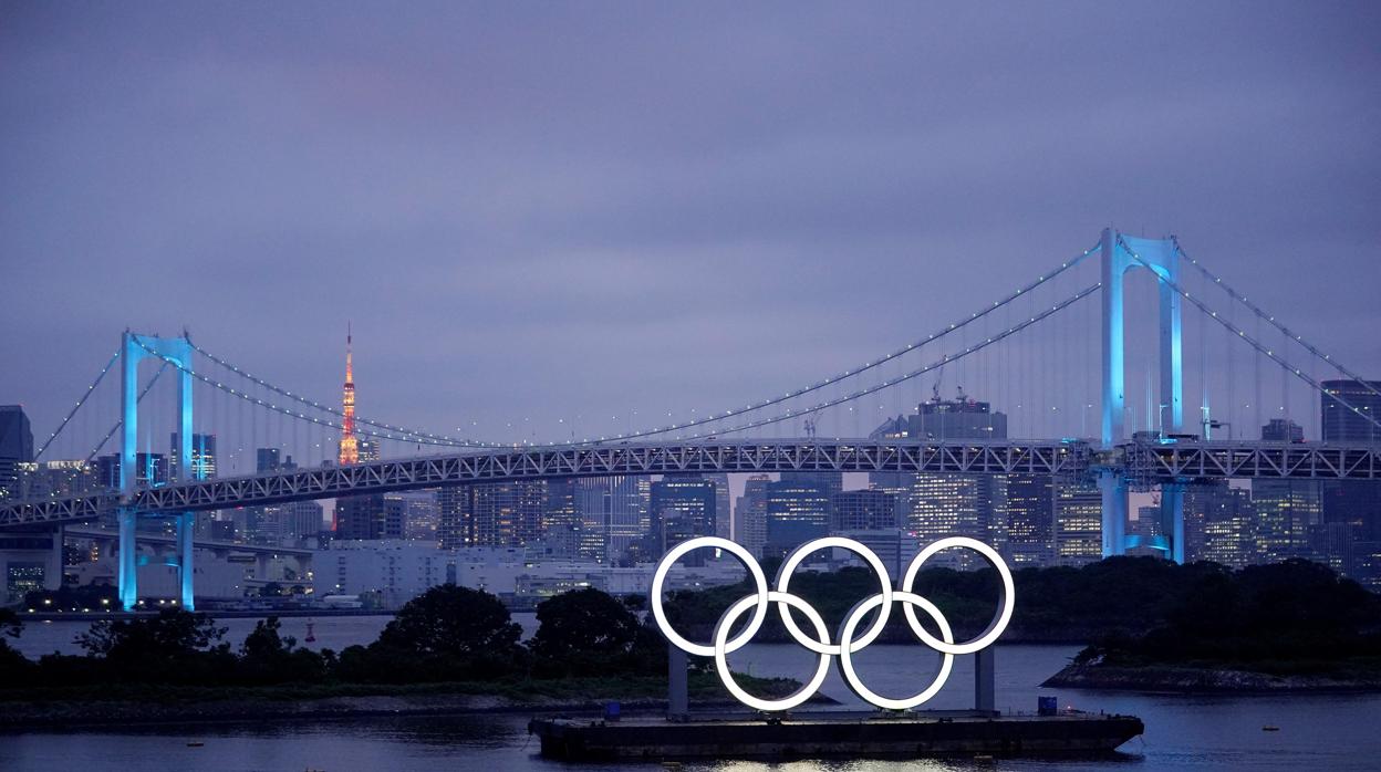 Los aros olímpicos iluminan el agua cerca del Puente del Arco Iris (Japón)