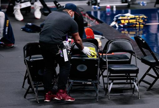 Un operario higieniza las sillas después de un tiempo muerto