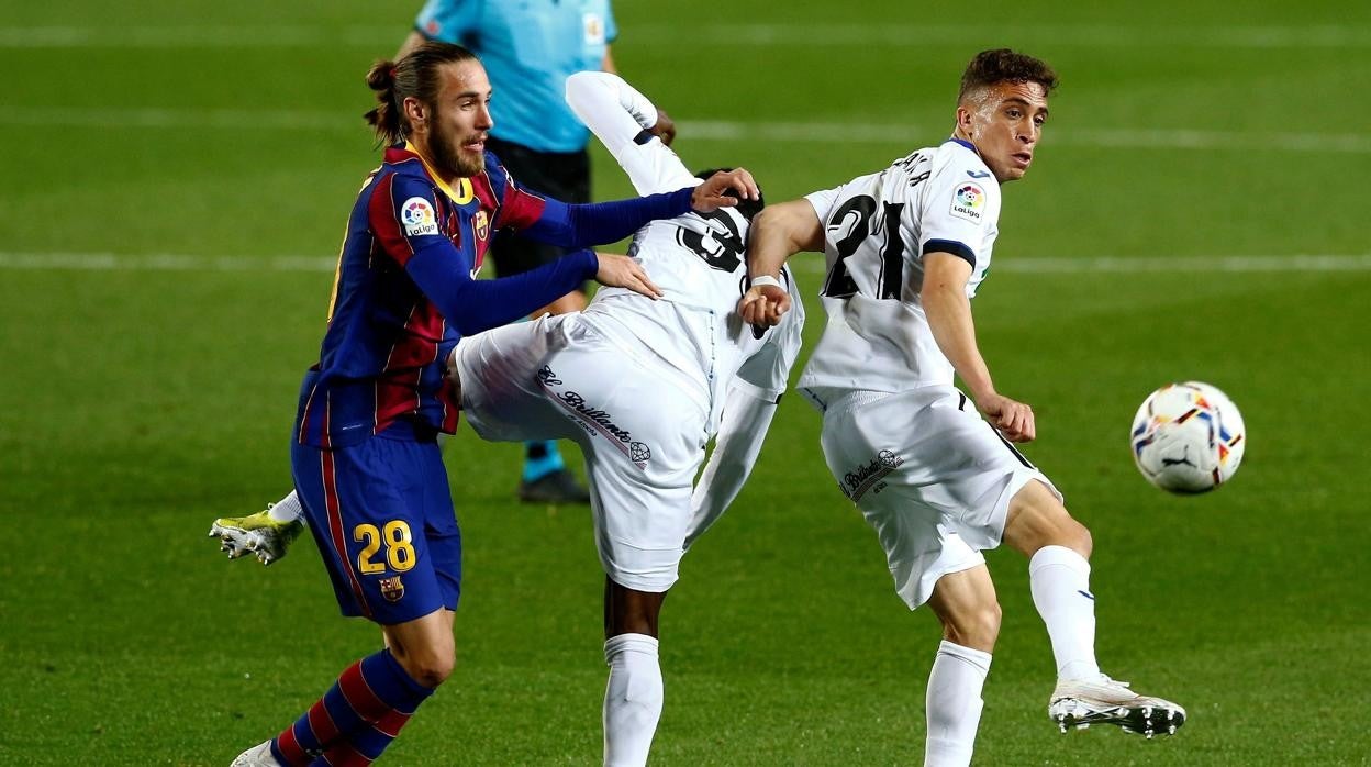 Mingueza pelea un balón con los jugadores del Getafe