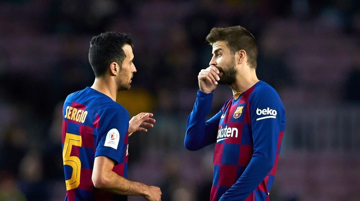 Piqué y Busquets intercambian impresiones durante un partido del Barcelona