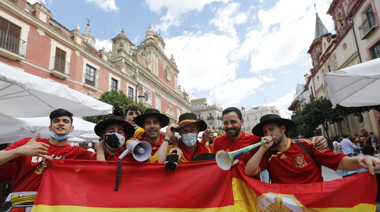 Un grupo de aficionados tiñe la plaza del Salvador de Sevilla de rojo y amarillo