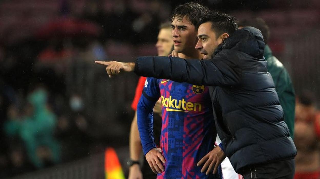 Xavi le da indicaciones a Gavi durante el partido ante el Benfica