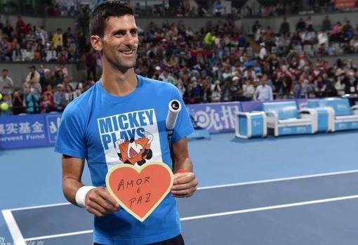 Djokovic sostiene un cartel donde se puede leer «Amor y paz»
